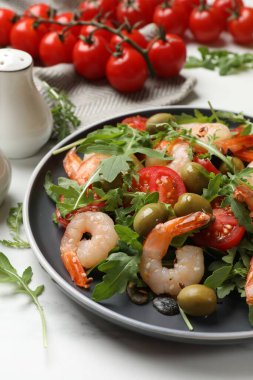 Domatesli lezzetli karides salatası ve beyaz mermer masada zeytin, yakın plan.