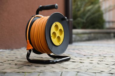 Asfaltta bir uzatma kablosu makarası açık havada, metin için boşluk