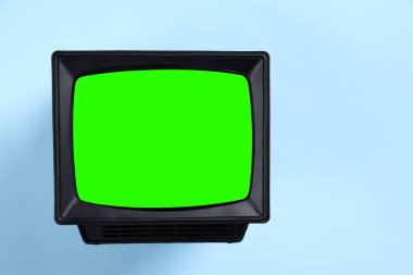 Açık mavi arka planda yeşil ekranlı Retro TV seti, tasarım için alan. Krom anahtar