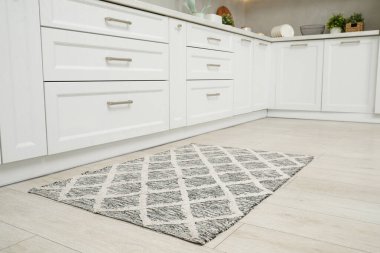 Mutfakta ahşap zeminde güzel bir halı.