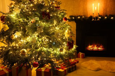 Güzel dekore edilmiş Noel ağacı, hediyeler ve şömine.