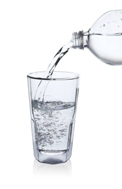 Pouring soda water from bottle into glass on white background