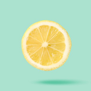 Açık turkuaz arka planda dilimlenmiş taze sulu limon. Citrus meyvesi.