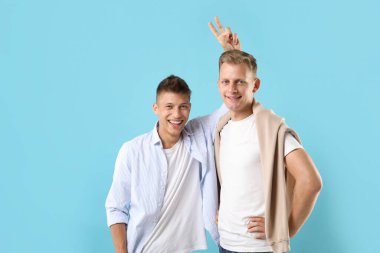 Açık mavi arkaplanda mutlu kardeşlerin portresi