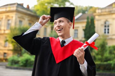 Mezuniyet töreninden sonra diplomalı mutlu bir öğrenci.