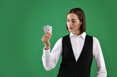 Yeşil arkaplanda oyun kartları olan krupiye