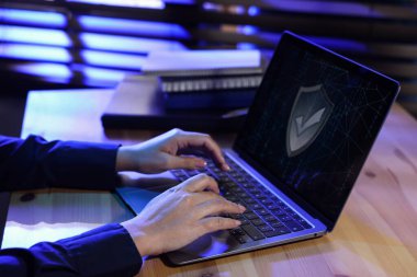 Siber güvenlik. Masada dizüstü bilgisayar kullanan bir kadın, yakın plan.