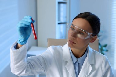 Laboratuvar testi. Doktor, içeride kan örneği olan test tüpünü tutuyor.