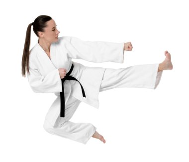 Kimonolu genç bir kadın beyaz arka planda karate yapıyor.