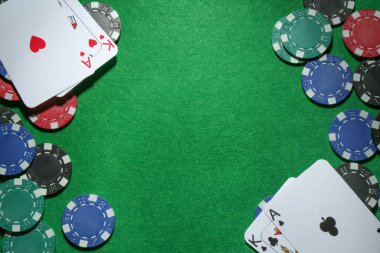 Poker fişleri çerçevesi ve yeşil masada iskambil kağıtları düz. Metin için boşluk