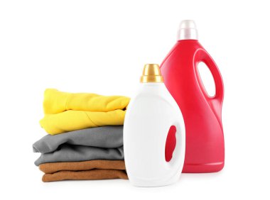 Çamaşır deterjanı şişelerde ve giysiler beyaza izole edilmiş.