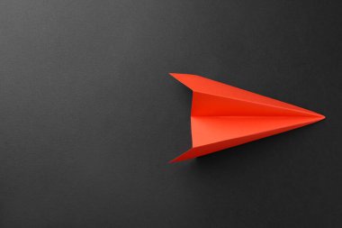Gri arka planda el yapımı turuncu kağıt uçak, üst manzara. Metin için boşluk