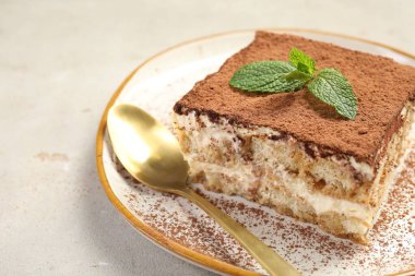 Bej masadaki lezzetli tiramisu parçası, yakın plan.