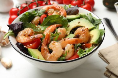 Lezzetli karides salatası ve malzemeler beyaz masada, yakın plan.