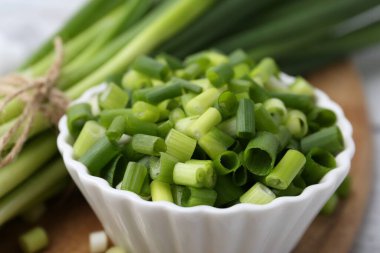 Kavanozda doğranmış yeşil soğan ve saplar masada, yakın plan.