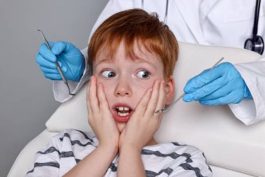 Dental phobia. Dentist working with scared little boy on grey background clipart