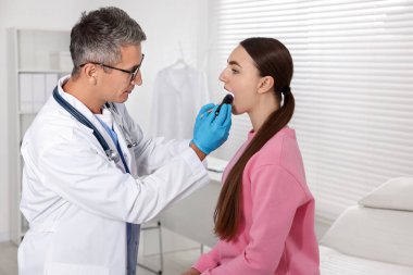 Klinikte kadının boğazını el feneri ile deşen doktor.