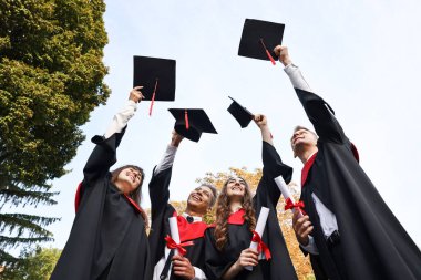 Mezuniyet töreni. Diplomalı bir grup öğrenci şapkalarını dışarı atıyor.