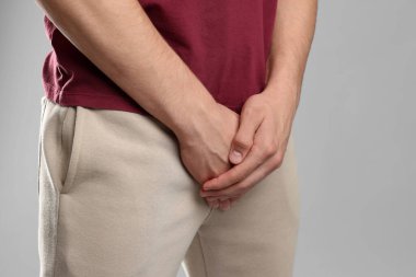 Cinsel yolla bulaşan hastalıklar. Gri arka planda semptomlardan muzdarip bir adam, yakın plan