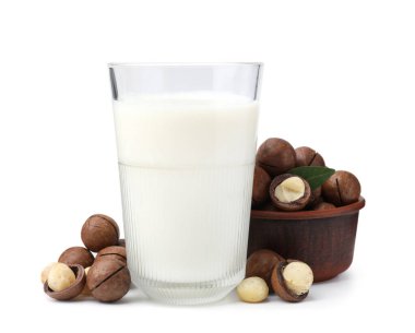 Beyaz üzerine izole edilmiş bir bardak Macadamia sütü ve fındık.