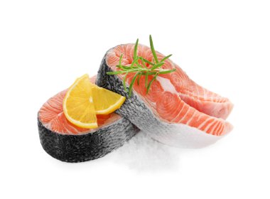 Taze çiğ somon biftekleri ve beyaz üzerine izole edilmiş baharatlar.