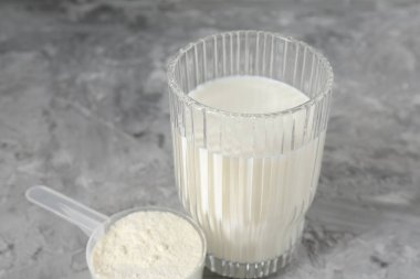 Lezzetli protein karışımı, cam ve toz ile kaplanmış gri desenli masa, yakın plan