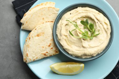 Kasede leziz humus, gri masada pide ve limon, üst manzara.