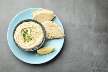 Kasede leziz humus, gri masada pide ve limon, üst manzara. Metin için boşluk