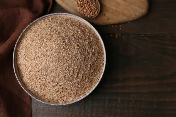 Karabuğday kepeği kasede ve tahıllar ahşap masada, üst manzara. Metin için boşluk