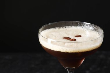 Siyah arka planda kahve çekirdekleri ile nefis espresso martini, yakın plan.