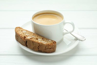 Geleneksel İtalyan badem bisküvisi (Cantucci) ve beyaz ahşap masada kahve, yakın plan.