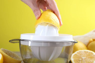 Tahta masada limonlu kadın meyve sıkacağı kullanıyor, yakın plan.