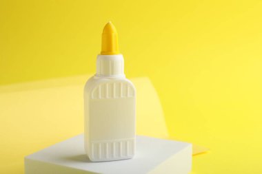 Sarı arka planda bir şişe yapıştırıcı. Metin için boşluk