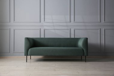 Gri duvarın yanındaki rahat kanepe.