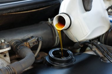 Otomobil motoruna motor yağı döken adam, yakın plan.