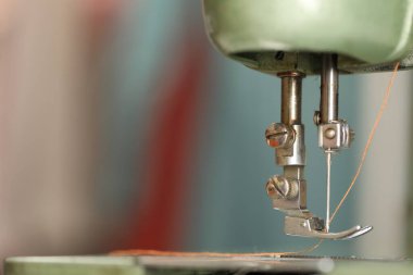 Bulanık arkaplanda ipliği olan klasik dikiş makinesi, makro görünüm. Metin için boşluk