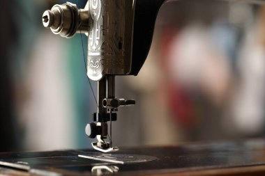 Bulanık arkaplanda ipliği olan klasik dikiş makinesi, makro görünüm. Metin için boşluk