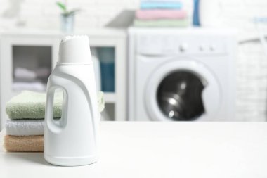 Çamaşır deterjanı ve temiz havlular beyaz masaya istiflenmiş, metin için boşluk