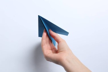 Beyaz arka planda el yapımı kağıt uçaklı kadın, yakın plan.