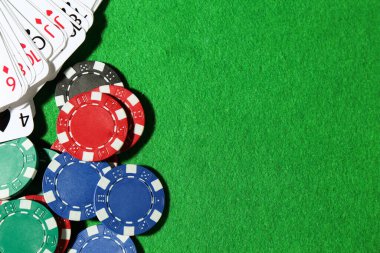 Yeşil masada kağıt ve poker fişleri, düz yatış. Metin için boşluk