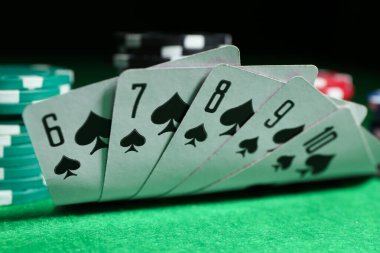 Playing cards and poker chips on green table, closeup clipart