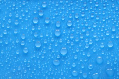Su damlaları mavi arkaplanda, üst görünümde