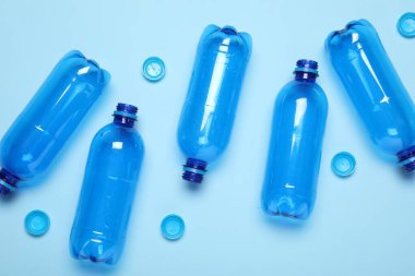 Işıklı arka planda plastik şişe ve kapaklar, üst görünüm