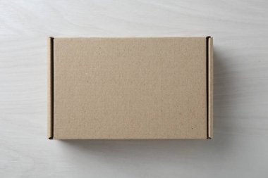 Beyaz ahşap arka planda boş bir karton kutu, üst manzara. Tasarım için model