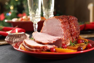 Lezzetli pişmiş jambon, siyah ahşap masada servis edilir, yakın plan.