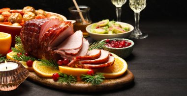 Lezzetli pişmiş jambon siyah ahşap masada servis edilir.