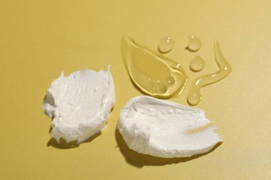Sarı arka planda farklı kozmetik ürünlerinin örnekleri, yakın plan