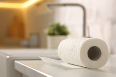 Mutfaktaki beyaz tezgahta kağıt havlu rulosu, yakın plan. Metin için boşluk