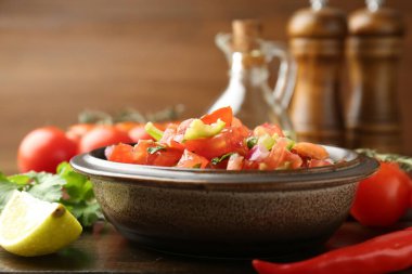 Ahşap masadaki malzemelerle nefis baharatlı salsa sosu. Yakın plan.