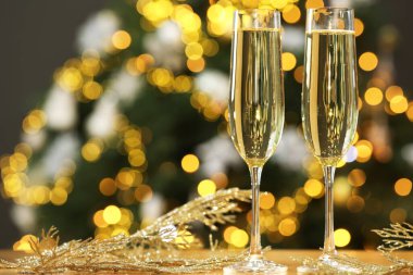 Gözlüklü şampanya ve masanın üstünde bulanık Noel ışıklarına karşı dekor, mesaj için yer. Bokeh etkisi